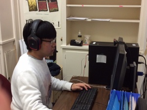 student sitting at a computer wearing headphones