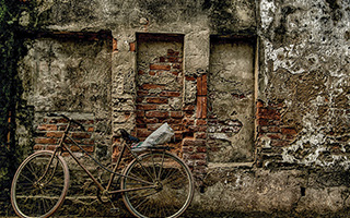a bicycle leaning against the wall of a building