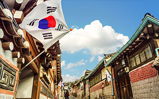 a street with a South Korean flag flying outside a building